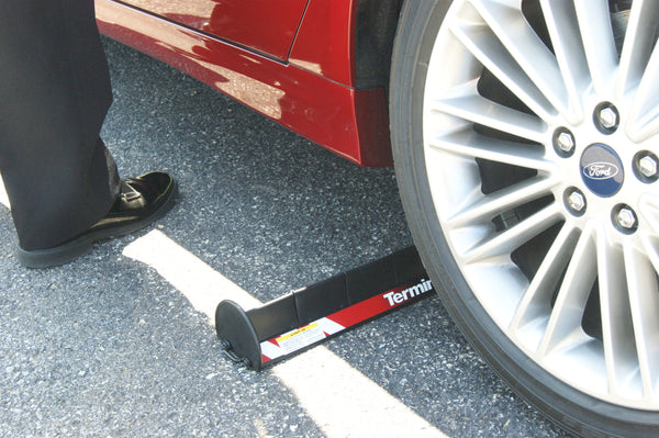 Stop Stick tyre deflation device puncturing the tyre of a red car during deployment